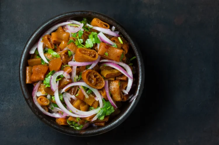 A clay bowl of seafood salad ceviche made with cochayuyo seaweed, onion, cilantro, and lemon.