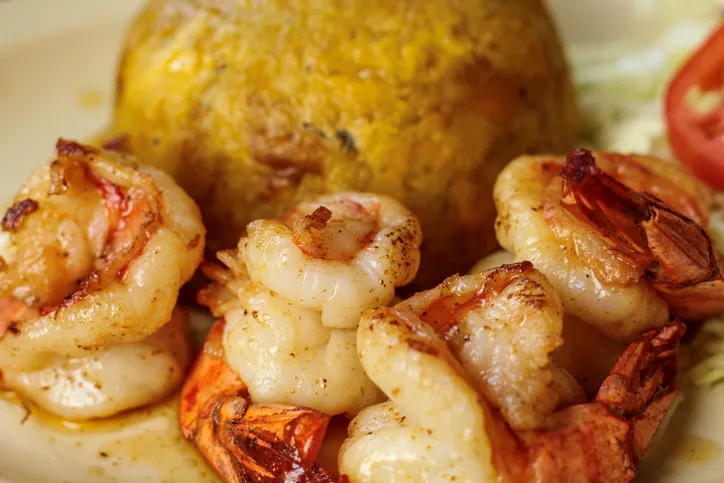 A close-up shot of the traditional Puerto Rican dish, Shrimp Mofongo, which is made using plantains and pork rinds.